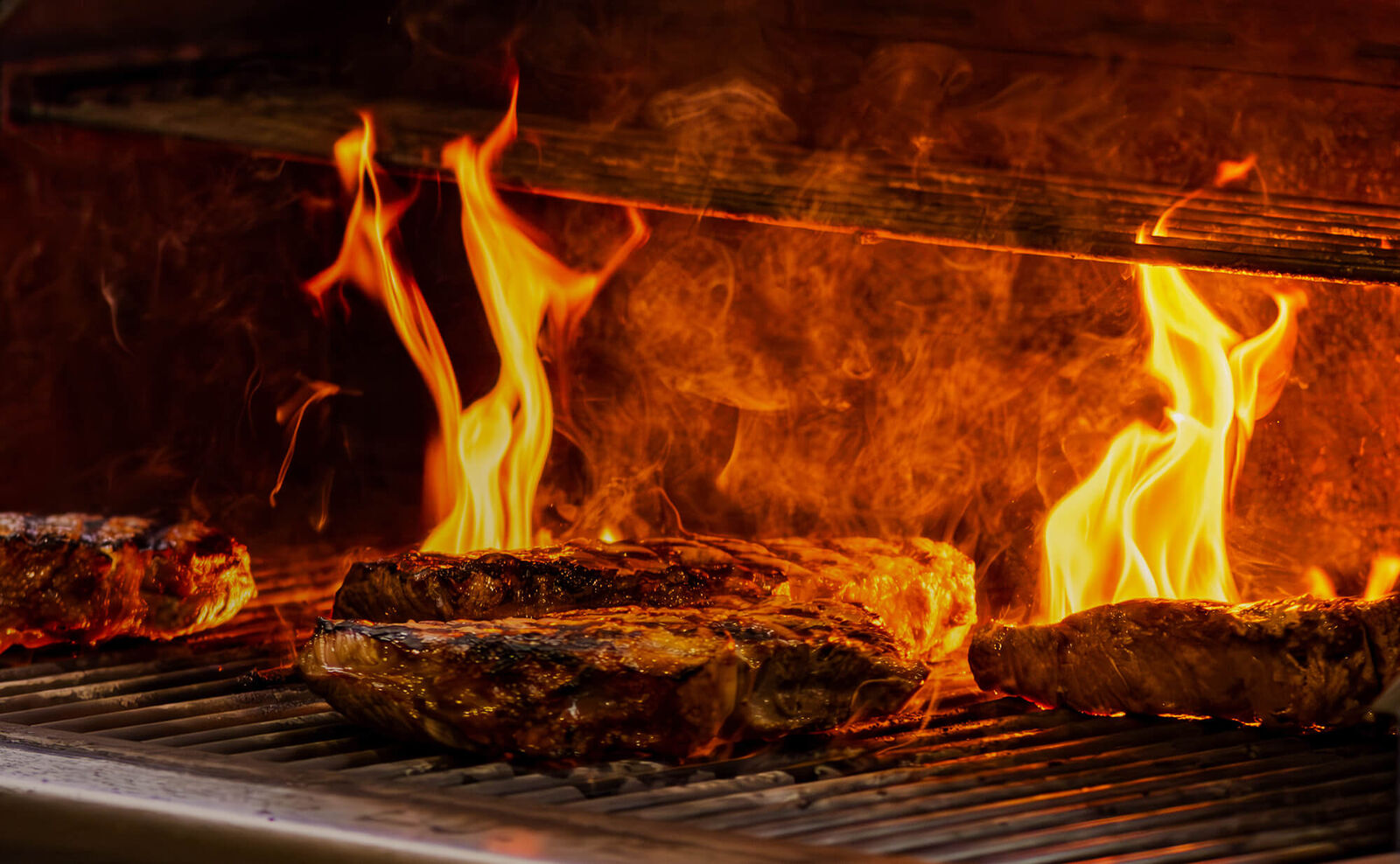 Fleischstücke liegen auf einem Grill