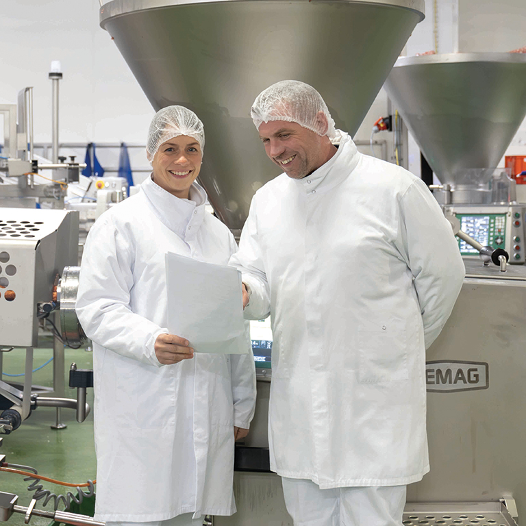 Personen stehen in Goldschmaus Produktion